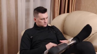 Protez kol, okuma alışkanlığı, rahat koltuklar. Engelli adam kitap ile koltukta rahatça oturuyordu..