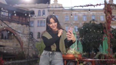 Günlük selfie, tek kişilik fotoğraf, anında paylaşım. Işıl ışıl genç bir kadın akıllı telefonuyla kendi fotoğrafını çeker..