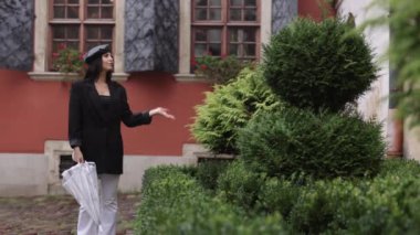 Şemsiye, yağışlı esmer, kahverengi saçlı serseri. Çikolata renkli saçlı bir kadın yağmur yağarken şemsiyeyle yürüyor.