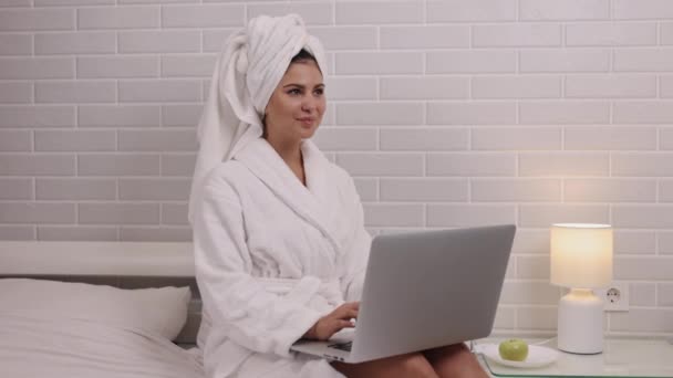 任务完成 个人空间的女人 为了舒适的卧室和浴衣 女人都沉浸在笔记本电脑上工作 — 图库视频影像