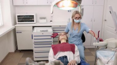 Doktor ortodontist, ortak muayene, ortodontik eklem. Ortodonti uzmanı kadın hastaların çene eklemlerini muayene ediyor.