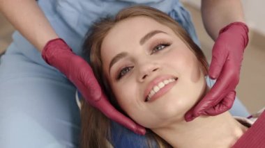 Çene değerlendirmesi, uzman teşhisi, ortodontik teşhis. Ortodontist-gnatholog kadın hastaların çene eklemlerini elle kontrol ediyor..
