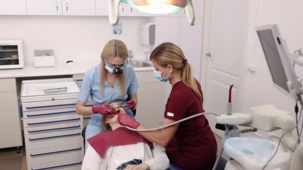 紫外線 歯科修復 歯科クリニック 歯科医院では 病理学者は回復プロセスの一部として患者の歯の光合成に紫外線を適用します — ストック動画