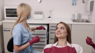 Dişçi kadın, kamera konsültasyonu, diş bakımı. Profesyonel diş hekimi, dişçi kamerasıyla genç bayan hastayı muayene ediyor..