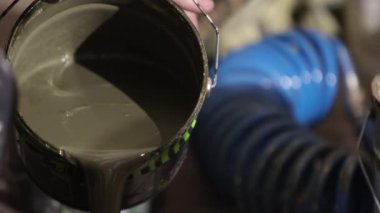 Boya tutacağı, renk karıştırma, erkek ressam. Tek başına, erkek ressam, boyayı metal kutudan ayırıyor..