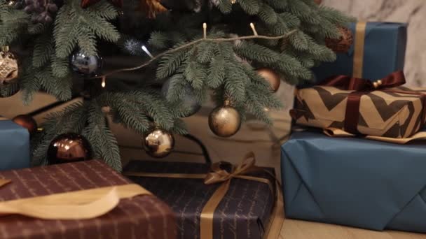 クリスマスのお祝い クリスマス 新年のプレゼント ギフトボックスはリボンで縛られ クリスマスの装飾で飾られています バックグラウンドは 部屋の火の木と美しいクリスマスギフトボックスです — ストック動画