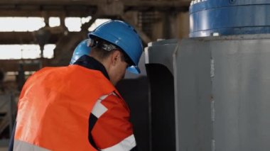 Teknik yardım, cıvata güvende, prosedürü sıkılaştır. Üretim tesisinde çalışanlar, cıvata somununu çalıştırmak ya da ayırmak için birlikte çalıştılar..