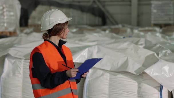 観察記録 製品検査 女性監査人 工場では 女性検査官が製品を検査し 白い袋の数を計算し 彼女の観察を記録する — ストック動画