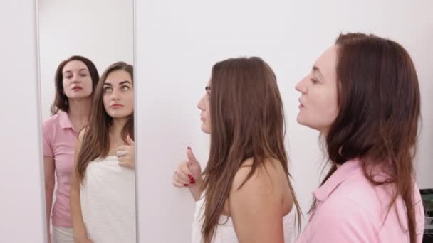 아름다움 미용사는 거울을 사용하여 클라이언트가 치료를 필요로하는 얼굴의 영역을 보여줍니다 — 비디오