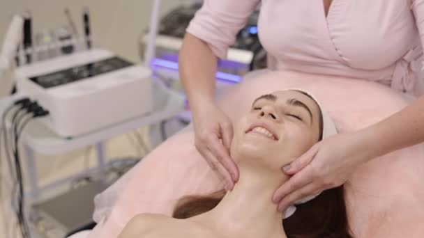 按摩技巧 皮肤营养 皮肤健康 女性美容师应用滋养霜 为客户提供年轻的按摩服务 — 图库视频影像