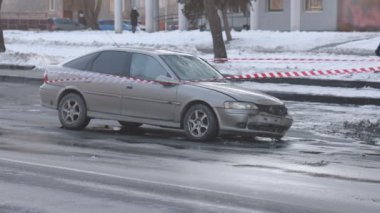 Kimlik tespiti yapılmış araba, ezilmiş araba, uyarı bandı. Otomobil, önden çarpma sonucu ciddi hasar görmüş, acil durum bandıyla sarılmış..