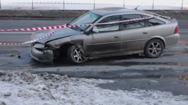 Araba kazası, araba hasarı, kaza mahalli. Otomobil, çarpışmadan sonra ön tarafı ezilmiş, uyarı bandıyla kapatılmış..