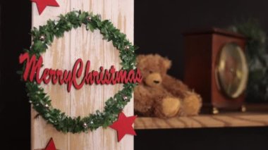 Noel dekoru, çelenk süsü, Noel Baba ayısı, Mutlu Noeller mesajı sevinçle kazınmış, tatil odalarının atmosferini güzelleştiriyor..