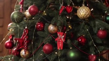 Güzel dekore edilmiş, Noel ağacı, çelenkler. Arka planda yoğun dekore edilmiş bir Noel ağacı. Ağaçtaki toplara yakın çekim. Arka planda Bokeh çelenkleri. Yeni yıl konsepti. Yakın plan.