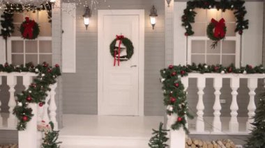 Noel dış görünüşü, Neşeli görünüm, çam çelengi. Noel beyaz evi süslenmiş, dışarısı manzaralı, kapıda patenler asılı..