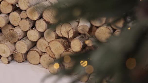 圣诞光芒 堆积木 堆积起来的木柴 模糊的圣诞树与闪光的灯在前景 — 图库视频影像