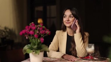 Serbest çalışan bir kız, çalışan bir iş kadını, şık bir beyaz. Bir kafede tek başına otururken telefonda tatlı tebessüm eden bir kadın ve Avrupa 'nın açık hava kafesinde telefon görüşmesi yapan bir iş kadını.