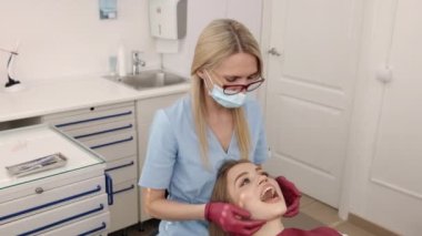 Çene teşhisi, ortodontik muayene, çene bakımı. Ortodontik ve gnatholojik muayene kadın hastaların çene eklemleri doktor tarafından yürütülüyor.