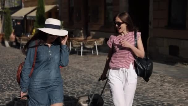 女探险家 旅行者手提箱 两位漂亮的女冒险家穿过街道 带着手提箱 尽情享受着她们的海外航行 — 图库视频影像