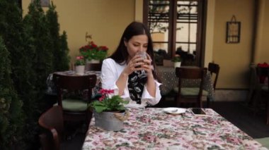 Kahve, lezzetli kapuçino, rüya gibi bir kadın. Hayalperest kadın kafeteryada kaybolurken cappuccino içiyor..