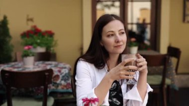 Sokak Kafesi, Hayalci Düşünceler, Düşünceli Kafe. Hayallere dalmış bir kadın kafeteryada kapuçinosunu yudumluyor..