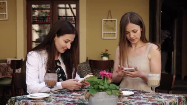 Просмотр Телефонов Телефонный Разговор Беседа Две Женщины Сидящие Кафе Погруженные — стоковое видео