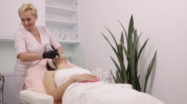 Müşteri danışmanlığı, cilt değerlendirmesi, tedavi süresi. Cilt bakımı danışmanı hasta için radyo frekans kaldırma olarak da bilinen RF kaldırma prosedürünü yürütür..