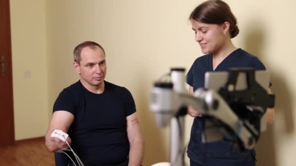 Terapia Ruchowa Osoby Niepełnosprawne Maszyny Rehabilitacyjne Mężczyzna Otoczeniu Klinicznym Otrzymuje — Wideo stockowe