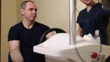 Terapi rehberliği, rehabilitasyon cihazı, klinik terapi. Hasta, terapötik rehberlik altında, uzmanlaşmış klinikte ileri düzey direksiyon mekanizması kullanarak el ve kol güçlendirme egzersizleri yapar..