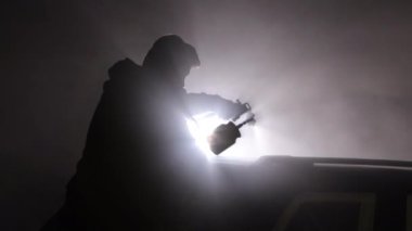 Solunum cihazı boyası, boya koruması, tiner. Bireysel sprey boyalı araba arka ışıklandırmayla vurgulanır, puslu çevreyle belirgin bir kontrast oluşturur.