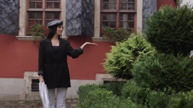 Yağmurlu bir gezinti, kumral yağmurlu bir yağmur, yağmurlu bir yolculuk. Şemsiye yağmurda yürürken siyah saçlı kadını korur..