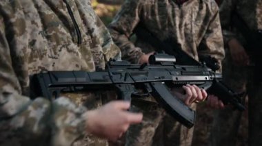 İnsanlar oynuyor, takım çalışması stratejisi, oyuncu koordinasyonu. Lazer Takımı katılımcıları kamuflaj kıyafetleri içinde ellerinde işaretlerle orman ortamında etkin bir şekilde duruyorlar.