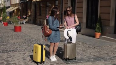 Tablet, GPS Tableti, Tech Seyahat 'e bakıyor. Günümüz seyahatleri tablet haritasında kendi rotalarını arayan iki kadın turiste yansıyor..