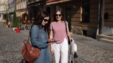 GPS Turizm, E-Seyahat, Uygulama Seyrüsefer. Tablet harita kullanarak yollarını belirleyen iki kadın turist tarafından dijital çağ turizmi gösteriliyor.