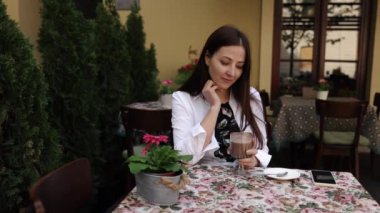 Aromatik kahve, kafeterya tefekkür, kahve düşünceleri. Kafede, düşünceli kadın yavaşça kapuçinosunu yudumluyor..