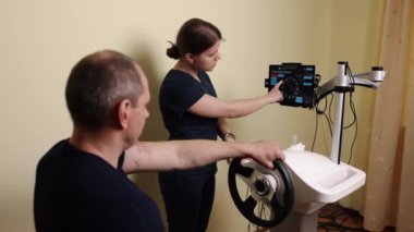 Tekerlek terapisi, rehabilitasyon cihazı, direksiyon terapisi. Uzman terapi kliniğinde, hasta son teknoloji direksiyon cihazı ile el ve kol güçlendirme ve rehabilitasyon uzmanı olarak çalışır..