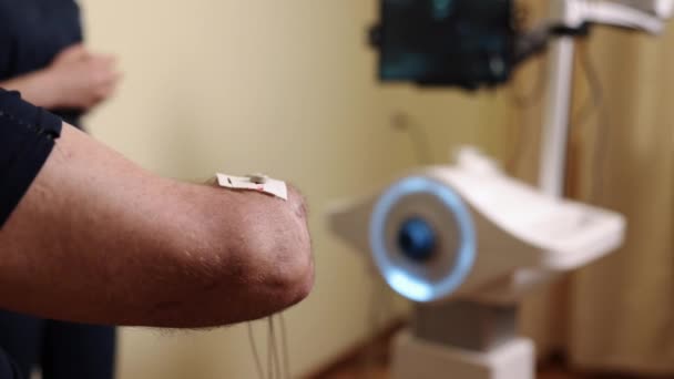 付属の電極 セラピー電極 電極ディテール 患者の腕の詳細なビューは リハビリに使用されるこの穏やかな筋肉刺激方法を示し 電気療法電極を明らかにします — ストック動画