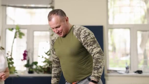 強度適応 筋力トレーニング プッシュアップトレーニング リハビリのトレーナーの監視下でプッシュアップを行うことによって 人工脚を持つ男は 彼のフィットネスで動作します — ストック動画
