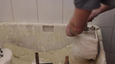 Protez Tasarım, Protez Üretimi, Kalıplı Protez. Kalça disartikülasyonu için protez bacak kalıbı oluşturma sürecinde, insan özenle alçıtaşı çözeltisine sarılır.