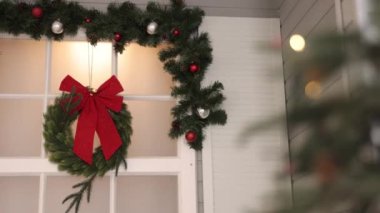 Dekor asma, çelenk, çelenk duvarı. Noel çelengi duvardan sarkıyor. Karmaşık bir şekilde örülmüş bayram şenliğiyle..