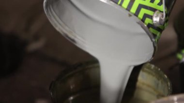 Konserve kutusu, hazırlık adımları, boya değişimi. Ressam metal boya kutusunun içindekileri farklı kutulara boşaltıyor..