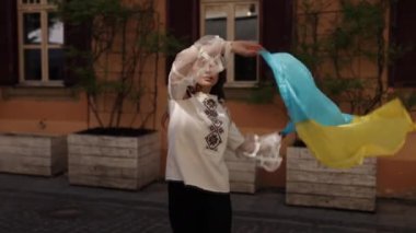 Saf vatanseverlik, Ulusal sembol, Gururlu ifade. Geleneksel işlemeli bluz giyen genç bayan, gururla Ukrayna 'nın mavi ve sarı ulusal bayrağını sergiliyor.