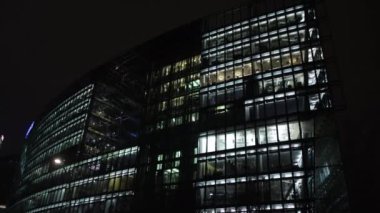 Şehir manzarası, Kule Yansımaları, Gece Gözlüğü. Gece şehrinde parıldayan cam ofis binaları.