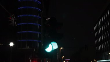 Trafik manzarası, şehir arkaplanı, şehir sokakları. Berlin 'de gece vakti, arka planda kentsel binalar bulunan trafik ışıkları gerçekçi bir manzara yaratır..