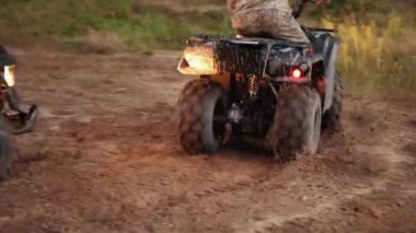 engebeli patika, engebeli açık hava, off-road yolu. Kamuflaj teçhizatı kullanan sürücüler engebeli araziyle uğraşırken toz bulutu saçarak engebeli toprak patikada ATV 'lerle yarışıyorlar..