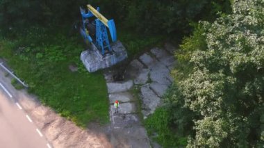 Hava görüşü, çevresel bütünleşme, doğal bütünleşme. Hava manzaralı yağ pompacısı, yüksek görüşlü yelek ve turuncu kask giyen işçiler pompa başında durup cihaza bakıyorlar..