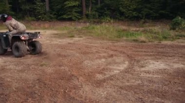 Off-road heyecanı, toz izi, toz heyecanı. Kamuflaj kıyafeti giymiş insanlar engebeli toprak yolda ATV 'lere biniyor, engebeli araziyi fethettiklerinde etraflarında toz bulutları uçuşuyor..