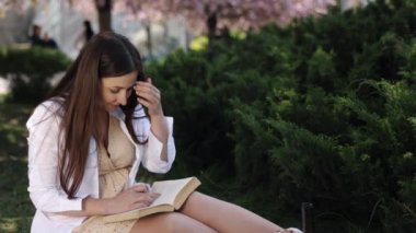 Açık hava edebiyatı, kadın açık hava, kitap okuma. Parktaki piknik sırasında, kadın oturur ve kitaba bakar..