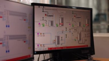 İzleme Odası, Kontrol Odası, Teknik Kontrol. Yakın çekim görüntü bilgisayar monitörü arayüzü gösteren endüstriyel bitki kontrol sistemi, karmaşık diyagramlar ve notlarla tamamlandı.