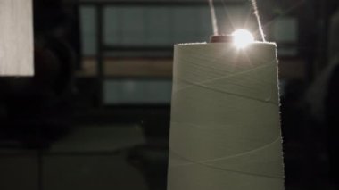 Bobinleri, aydınlatılmış ipliği, aydınlatma düzeneğini temsil ediyor. Parlak işaret fişeği fabrikasıyla aydınlatılan beyaz bobin ipliği.